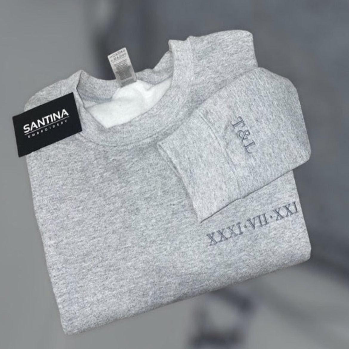 Unique Roman numeral sweatshirt with custom embroidery and gray fabric.