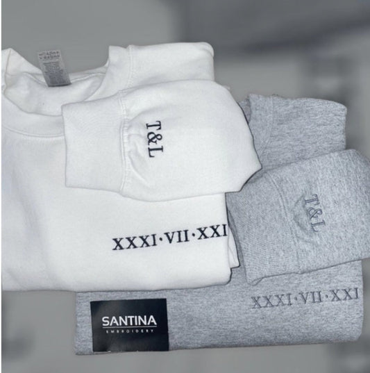 Custom embroidered Roman numeral sweatshirt with black text on white fabric.